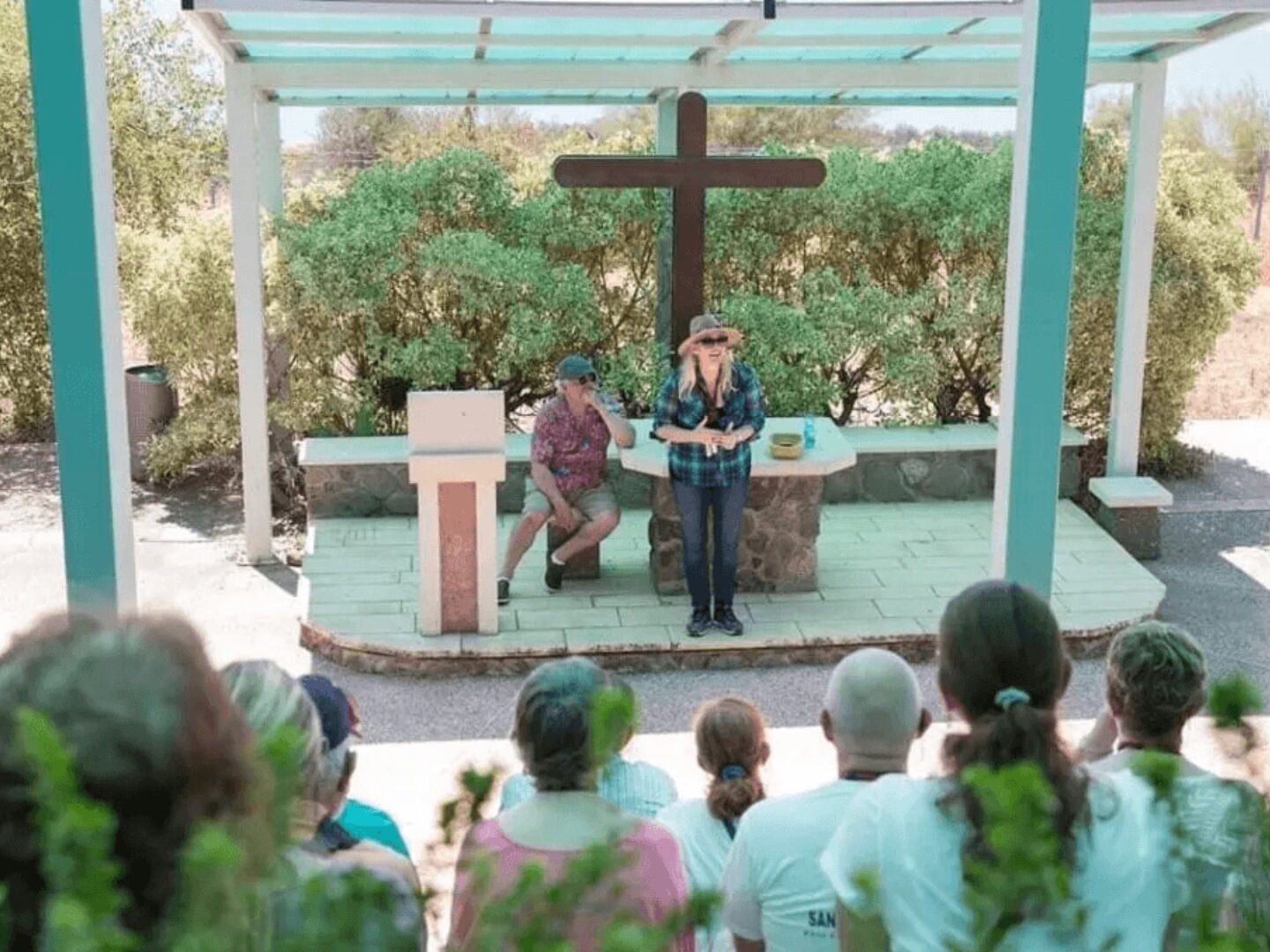 A woman is speaking at an outdoor church.