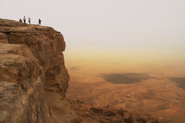 A person standing on top of a cliff.