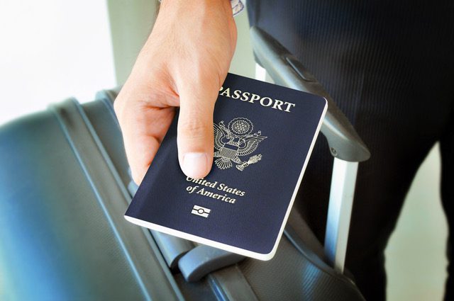 A person is holding their passport in his hand.