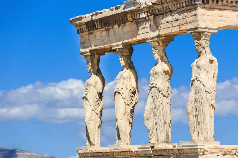 A group of statues that are standing in the sand.