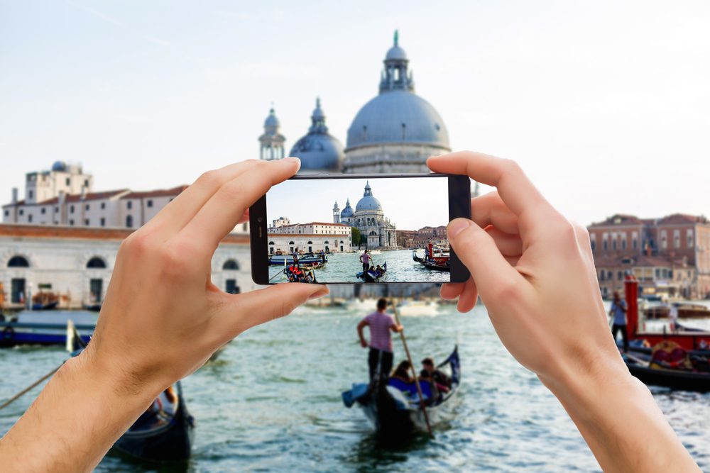 A person taking a picture of some people in boats