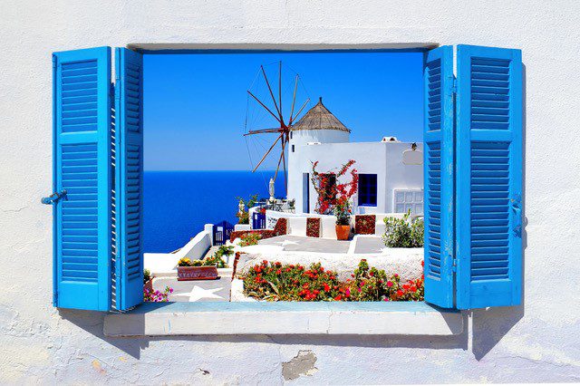 A window with shutters open to the outside of a house.