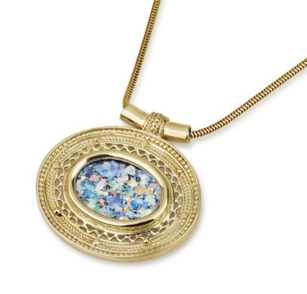 A gold necklace with a round pendant and blue glass.